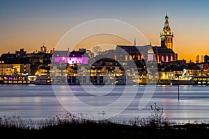 Dutch city of Nijmegen in the evening, Waterfront of river Waal and majestic Steven\'s Church