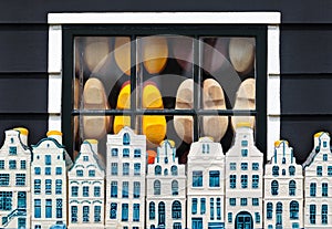 Dutch clogs behind a window and souvenir Amsterdam houses