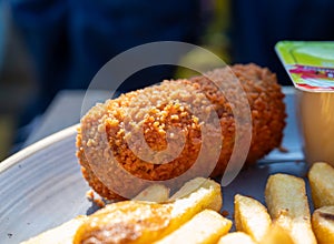 Dutch fast food, deep fried croquettes filled with ground beef meat and french fried potatoes chips served with green salad, close