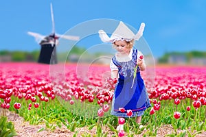 Dutch girl in tulip field in Holland