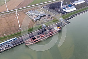 Dutch harbor Eemshaven with wind turbines and and freighter transporting coals