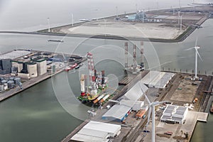 Dutch harbor Eemshaven with wind turbines and offshore construction platforms