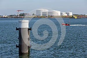 Dutch harbor Vlissingen with steel bollard and oil storage tanks