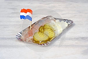 Dutch snack, seafood sandwich with herring, onions and pickled c