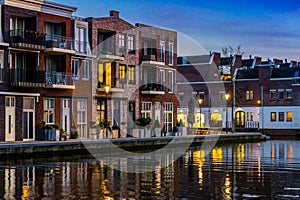 Dutch houses at the canal by night, City architecture of Alphen aan den Rijn, the Netherlands