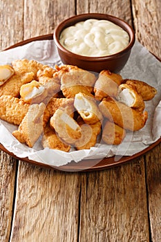 Dutch Kibbeling Deep Fried Battered Fish Pieces with remoulade sauce closeup in the plate. Vertical