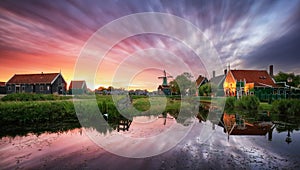 Dutch landscape with windmill at dramatic sunset, Zaandam, Amsterdam, Netherlands photo