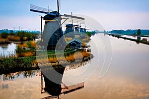 Dutch landscape, windmills at Kinderdijk village, a famous authentic tourism attraction in the Netherlands on sunset.