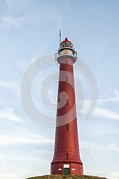 Large and high Dutch lighthouse on top of a hill