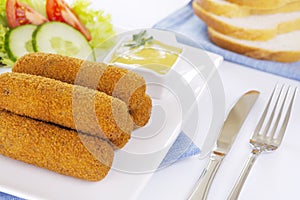 Dutch meat croquettes `kroket` and bread on a plate