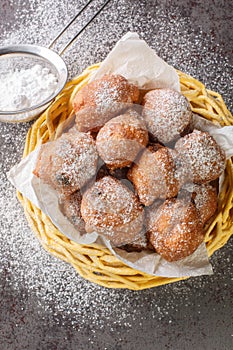 Dutch Oliebollen Oil Balls are also sometimes called Dutch Donuts or Dutch Dough Balls closeup in the basket. Vertical top view