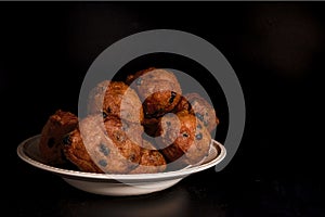 Dutch oliebollen in a white bowl with rasins