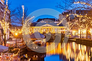 The Dutch Oude Rijn canal with bridge, historic buildings and christmas lights in the city center of Leiden photo