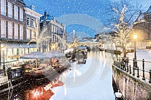 The Dutch Oude Rijn canal with bridge, historic buildings and christmas lights in the city center of Leiden photo