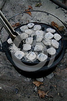 Dutch oven with briquettes and tongs