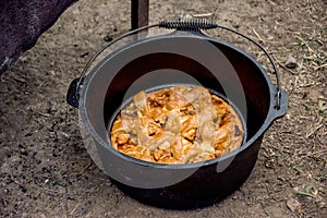 Dutch oven campfire cooking - baking an apple pie in cast iron camp oven