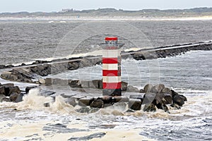 Dutch pier IJmuiden with lighthouse and stormy sea