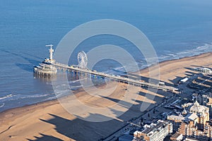 Dutch pier Scheveningen with long shadows Kurhaus at the beach