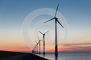 Dutch row offshore wind turbines at beautiful sunset