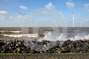 Dutch sea with off shore wind turbines and breaking waves