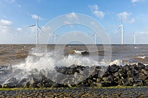 Dutch sea with off shore wind turbines and breaking waves