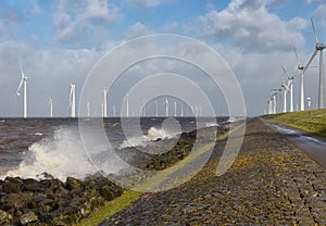 Dutch sea with off shore wind turbines and breaking waves