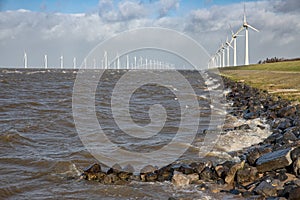 Dutch sea with off shore wind turbines and breaking waves