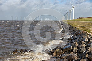 Dutch sea with off shore wind turbines and breaking waves