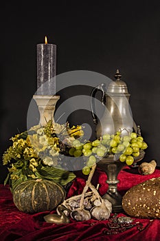 Dutch still life with grapes and draperies on a black background.