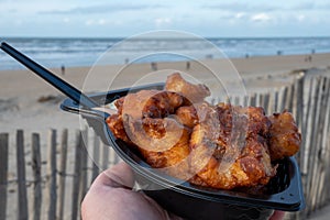 Dutch street seafood, deep fried cod fish fillet with garlic sauce called in Netherlands kibbeling and North sea beach on