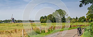 Dutch summer panorama with windmill and bike
