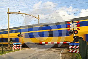 Dutch train passing a railway crossing