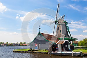 Dutch typical landscape. Traditional old dutch windmill against blue cloudy sky in the Zaanse Schans