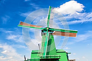 Dutch typical landscape. Traditional old dutch windmill against blue cloudy sky in the Zaanse Schans village, Netherlands. Famous