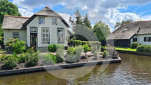 Dutch village with colorful ornamental garden and spring flowers, Giethoorn