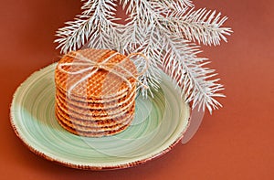 Dutch waffle stroopwafel background cookies round brown pastries plate blue christmas tree white yellow