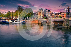 Dutch water canals with moored boats at sunset, Amsterdam, Netherlands