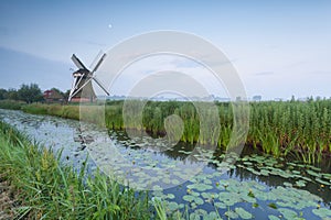 Dutch windmill bu river and moon