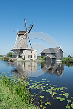 Dutch windmill at a canal on a sunny summer day