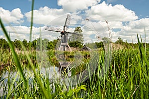 Dutch windmill in the landscape of the Dutch polder with marsh p