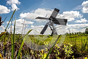 Dutch windmill in the landscape of the Dutch polder with marsh p