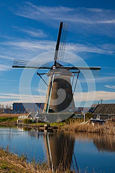 Dutch windmill reflecting in the canal water in Kinderdijk Holland