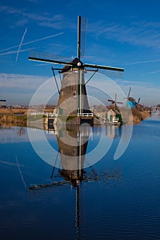 Dutch windmill reflecting in the canal water in Kinderdijk Holland