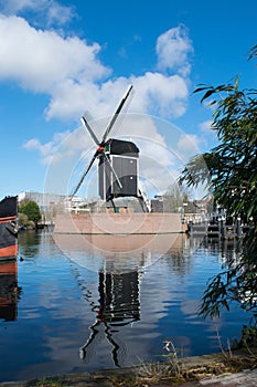 Dutch windmill reflecting in the river Rijn photo