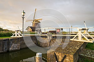 Dutch windmill and sluice near river Rotte in Holland
