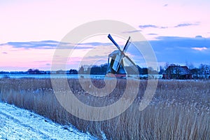 Dutch windmill in winter at sunrise