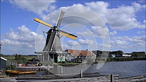 Dutch windmill working on canal at Zaanse Schans, Holland