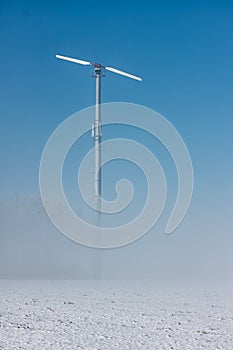 Dutch winter landscape with ground fog and wind turbine