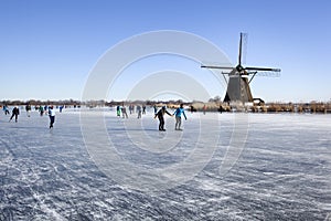 Dutch winter landscape with Ice skaters and a windmill
