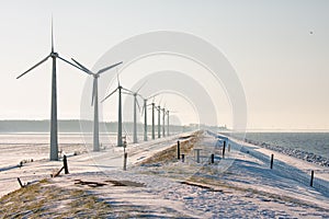 Dutch winter landscape with snow , windturbines and skyline Urk